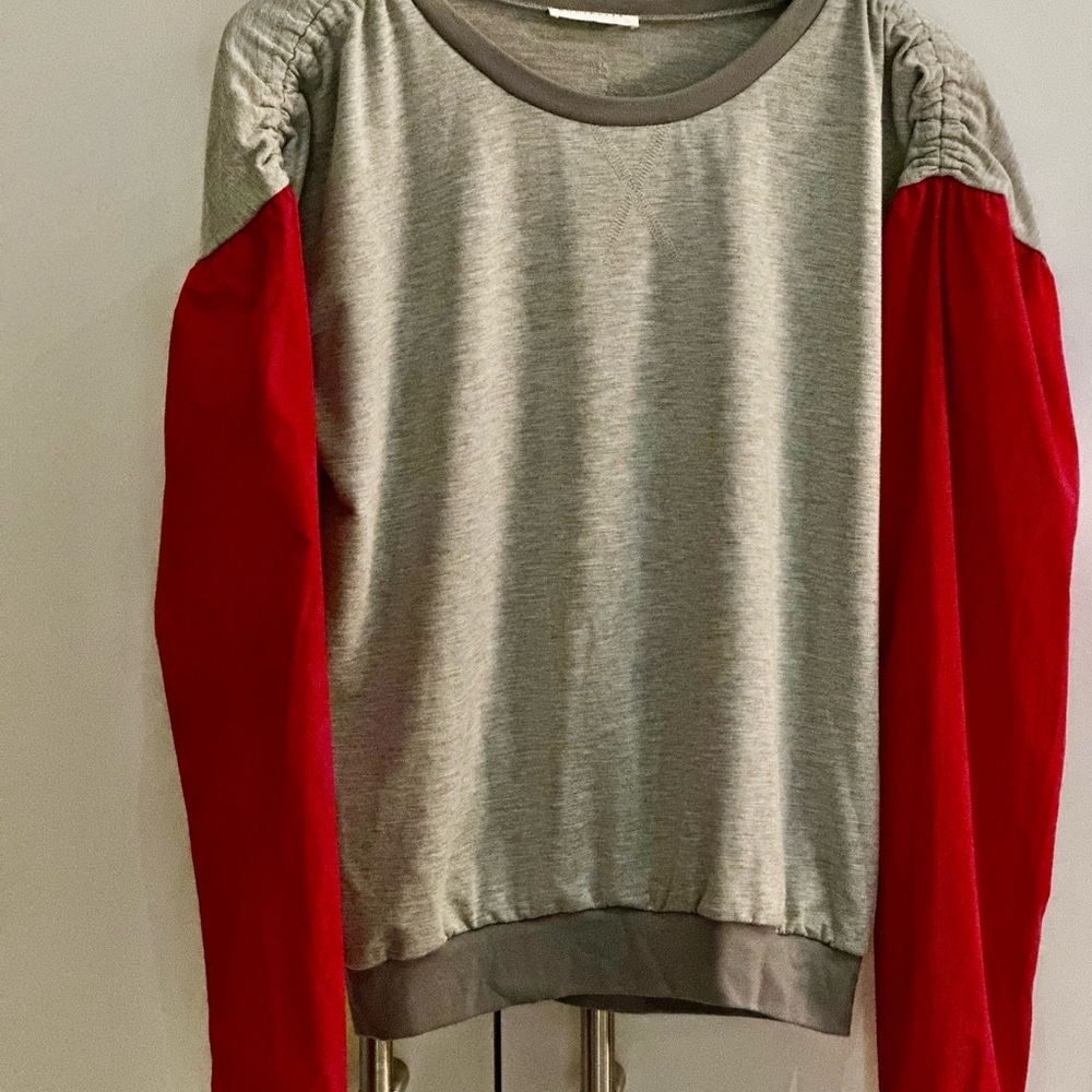 Adorable top with slight puffy shoulder and red sleeve
